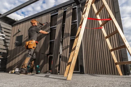 carpenter-installing-wooden-panels-outdoor-structure-daylight